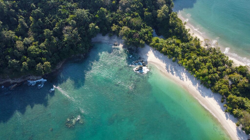 Stunning aerial shot of the lush coast and clear water at Manuel Antonio Beach in Costa Rica.