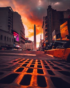The Obelisk of Buenos Aires captured at twilight with dramatic sky and vibrant colors.