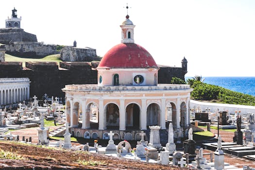 A picturesque view of the historic cemetery in Old San Juan, Puerto Rico, featuring ornate tombstones and ocean backdrop.