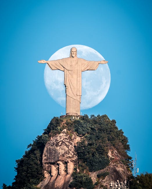 Iconic Christ the Redeemer statue with full moon backdrop, captured in Rio de Janeiro.