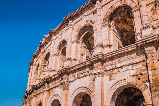 A stunning view of the ancient Roman amphitheatre under a clear blue sky in Nîmes.