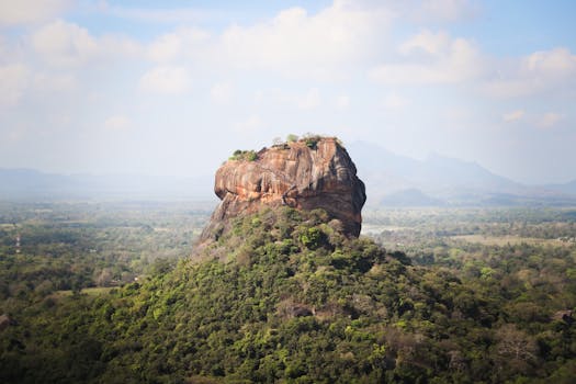 View of the iconic Sigiriya Rock Fortress, surrounded by lush vegetation in Sri Lanka.