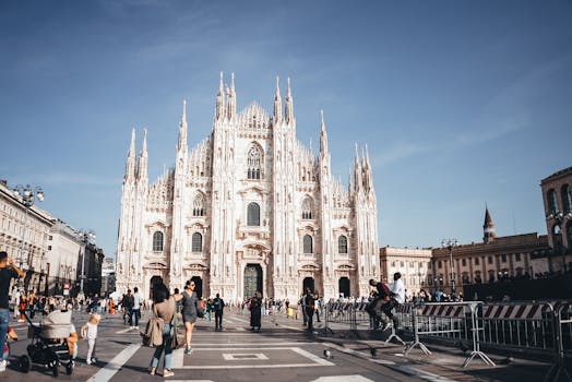 Capture of the majestic Milan Cathedral, showcasing its stunning Gothic architecture in a lively city square.