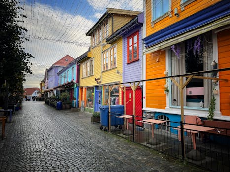 Cobblestone street with vibrant wooden houses in Stavanger, Norway, perfect for travel photography.