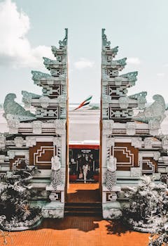 Traditional Balinese gate at Bali Airport with an airplane in the background, capturing the cultural essence.